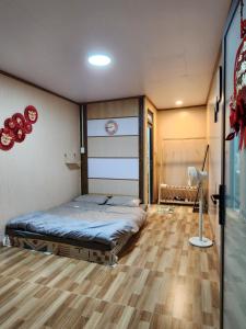 um quarto com uma cama e piso em madeira em Xóm nhà lá homestay em Da Lat