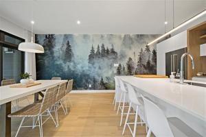 uma cozinha com uma grande pintura de árvores na parede em Verbier by Tremblant Platinum em Mont-Tremblant