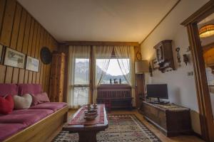 a living room with a purple couch and a window at Villa Aurora in Pocol