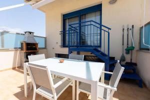 une salle à manger avec une table et des chaises blanches dans l'établissement Brisa del Delta, à L'Ampolla