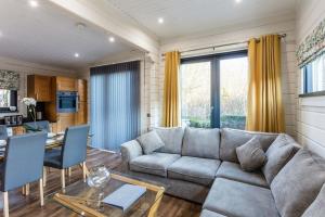 uma sala de estar com um sofá e uma mesa em Roydon Marina - Lodge 4 - Hot Tub em Roydon