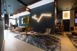a lobby with chairs and tables and a wall at Axis Porto Club Aliados in Porto
