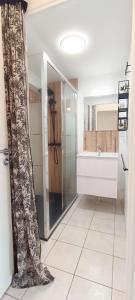ein Bad mit einer Dusche und einem Waschbecken in der Unterkunft Semaphore2- Maison au calme - Piscine - La Chaume in Les Sables-dʼOlonne