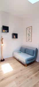 Bett in einem Zimmer mit blauem Sofa in der Unterkunft Semaphore2- Maison au calme - Piscine - La Chaume in Les Sables-dʼOlonne
