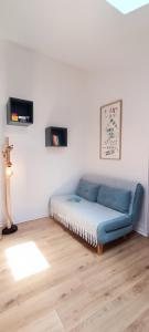 a bed in a room with a blue couch at Semaphore2- Maison au calme - Piscine - La Chaume in Les Sables-dʼOlonne