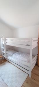 2 weiße Etagenbetten in einem Zimmer in der Unterkunft Semaphore2- Maison au calme - Piscine - La Chaume in Les Sables-dʼOlonne