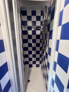 y baño con ducha y azulejos azules y blancos. en Rifugio dell'Ulivo near Assisi, en Rivotorto