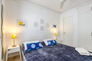 1 dormitorio blanco con 1 cama y 2 lámparas en CUBAN GREEN Terrace en Sitges
