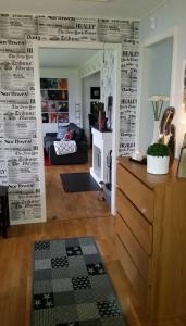 a living room with a wall covered in newspapers at Mysigt rum i trevligt hus in Taberg