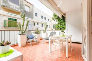 balcón con mesa, sillas y plantas en CUBAN GREEN Terrace en Sitges
