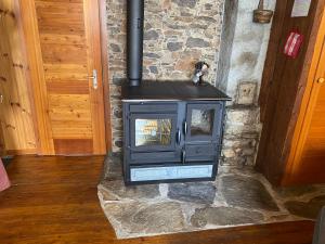 a black stove in a room with a stone wall at Alphütte Bielerchäller in Fiesch