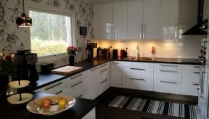 a kitchen with white cabinets and a plate of fruit at Mysigt rum i trevligt hus in Taberg