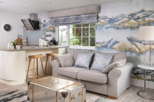 a living room with a couch and a kitchen at Marys Cottage, Grasmere, Dog Friendly, Hot Tub in Grasmere