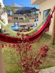 a hammock in a yard with a table and an umbrella at Casa Conchas do Patacho in Pôrto de Pedras +75 photos