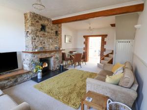 a living room with a couch and a fireplace at Lantern Cottage in Colyton