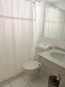 HOTEL DACARLO في سانتياغو: حمام ابيض مع مرحاض ومغسلة