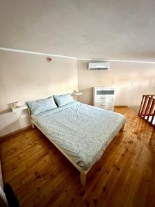 1 dormitorio con 1 cama y suelo de madera en Casa Brescia, en Turín