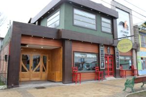 ein Restaurant mit roten Stühlen vor einem Gebäude in der Unterkunft Hotel Milodon in Puerto Natales + 17 Fotos