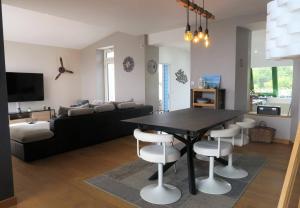 a living room with a black table and white chairs at Maison 6 pers, avec jardin clos au centre de Trégastel, à 500m de la plage - Réf 179 in Trégastel