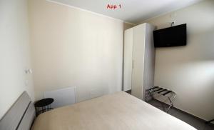 a bedroom with a bed and a tv on the wall at Le Case Di Nonna Angela in Matera