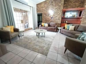 a living room with couches and a table at Shingalana Guest Lodge in Hazyview