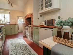 a kitchen with green cabinets and a counter top at Stag Cottage in Minehead