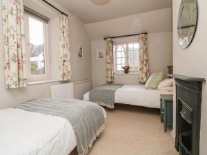 a bedroom with two beds and a mirror at Stag Cottage in Minehead