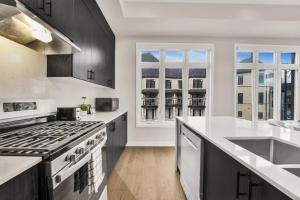 a kitchen with black and white appliances and windows at Modern Living in Vaughan - Brand New 3BR House in Vaughan