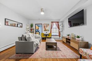 a living room with a couch and a tv at 1BR Brownstone w Rare Outdoor Space in New York