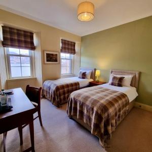 Pokój hotelowy z 2 łóżkami, stołem i biurkiem w obiekcie Loch Maree Hotel w mieście Talladale
