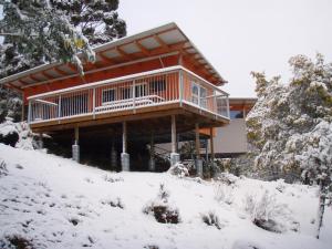 una casa en una colina nevada en la nieve en Base Camp Tasmania, en New Norfolk