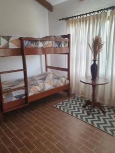 a room with two bunk beds and a table with a vase at Casa - Villa Real de Aragón in Cochabamba