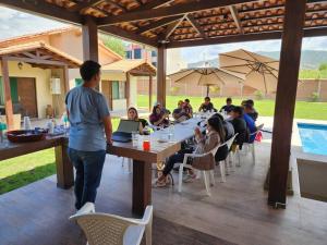 a group of people sitting at tables with laptops at Casa - Villa Real de Aragón in Cochabamba