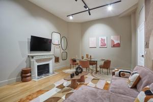 - un salon avec un canapé, une télévision et une table dans l'établissement Residence Trocadero by Studio prestige, à Paris