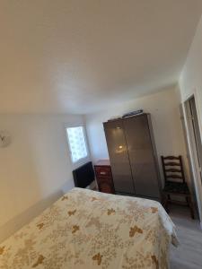 um quarto com uma cama, um armário e uma janela em Charmant appartement type T2 proche de la mer em Le Grau-du-Roi