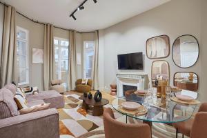- un salon avec une table en verre et des miroirs dans l'établissement Residence Trocadero by Studio prestige, à Paris