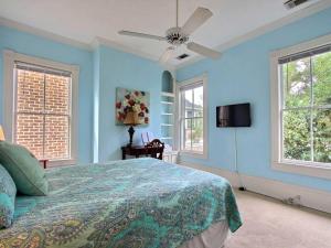 a bedroom with blue walls and a bed with a ceiling fan at Washington Square Manor in Savannah