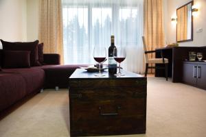 a living room with a bottle of wine and two glasses at Hotel ALTIS in Námestovo