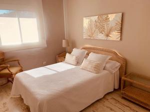 a bedroom with a bed with white sheets and a window at Exclusivo ático frente al Mar en s'Agaró in Girona