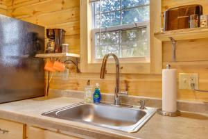 a kitchen with a sink in a wooden kitchen at Mauston Studio Cabin about 15 Mi to Wisconsin Dells! in Lyndon Station