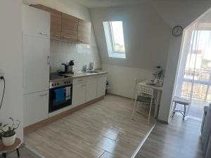 eine Küche mit weißen Schränken und einem Waschbecken und einem Tisch in der Unterkunft Über den Dächern von Halle in Halle an der Saale + 20 Fotos