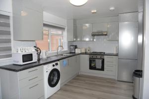 a white kitchen with a sink and a microwave at brook house in London