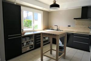 kuchnia z drewnianym stołem i zlewem w obiekcie Maison avec jardin, WIFI, à 50m de la plage à TREGASTEL - Réf 195 w mieście Trégastel