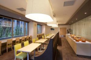 un comedor con mesas, sillas y ventanas en Keio Presso Inn Akasaka, en Tokio