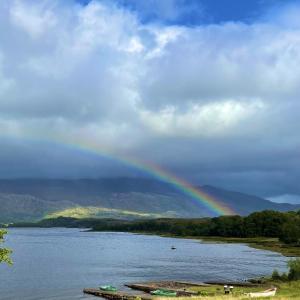 un arco iris sobre un río con un barco en el agua en Loch Maree Hotel, en Talladale