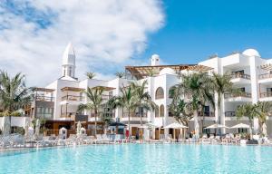 a hotel with a swimming pool in front of a building at Princesa Yaiza Suite Hotel Resort in Playa Blanca