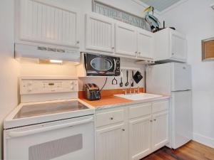 een keuken met witte kasten en een magnetron bij Beach Walk 4 in Tybee Island