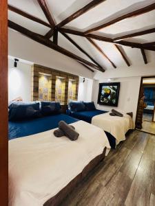 Cette chambre dispose de deux lits et d'un canapé dans un plafond en bois. dans l'établissement Cabaña Ensueño, à Villa de Leyva