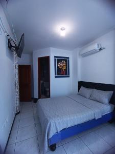 a bedroom with a bed and a television in it at Hostal Venecia -Tu casa en Manta. in Manta