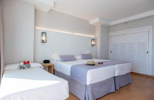 two beds in a room with white walls at Estival Torrequebrada in Benalmádena